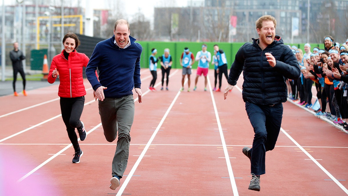 Prince Harry smiling as he runs in a race with Prince William and Kate Middleton