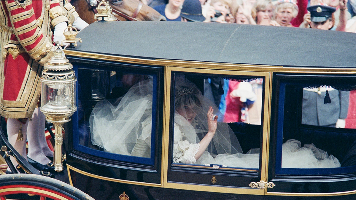 Princess Diana sitting inside a glass coach in her wedding dress
