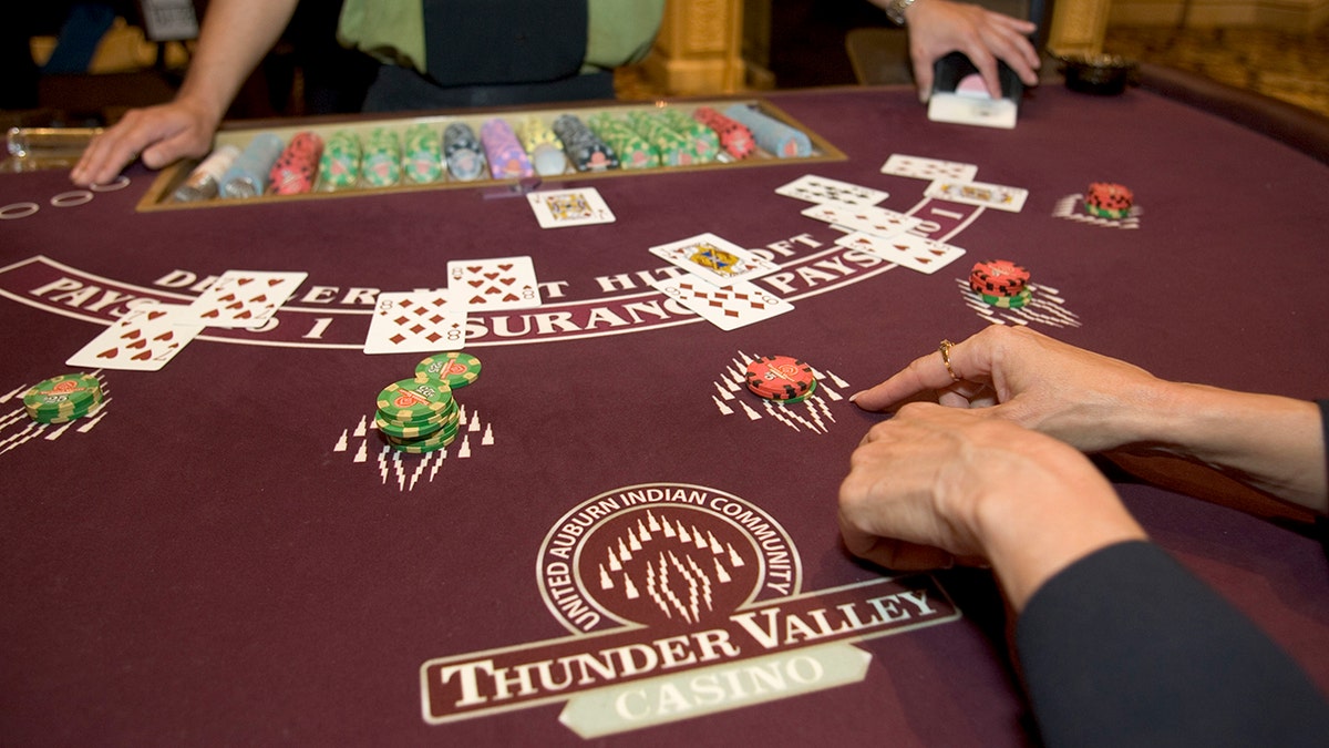 Two people playing Blackjack at a casino