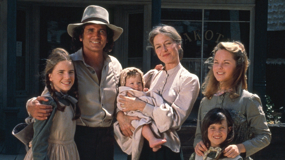 The cast of Little house in costume smiling and facing the camera