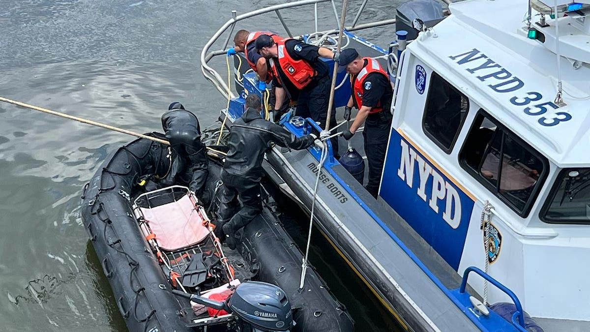 NYPD boats in the water coordinate to lift the body onto the boat