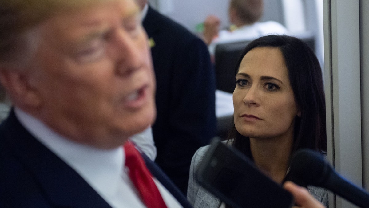 White House Press Secretary Stephanie Grisham listens as President Donald Trump speaks