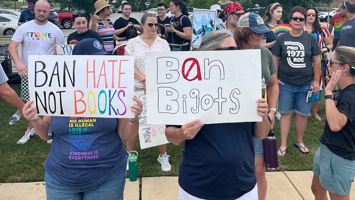 Two people holding signs