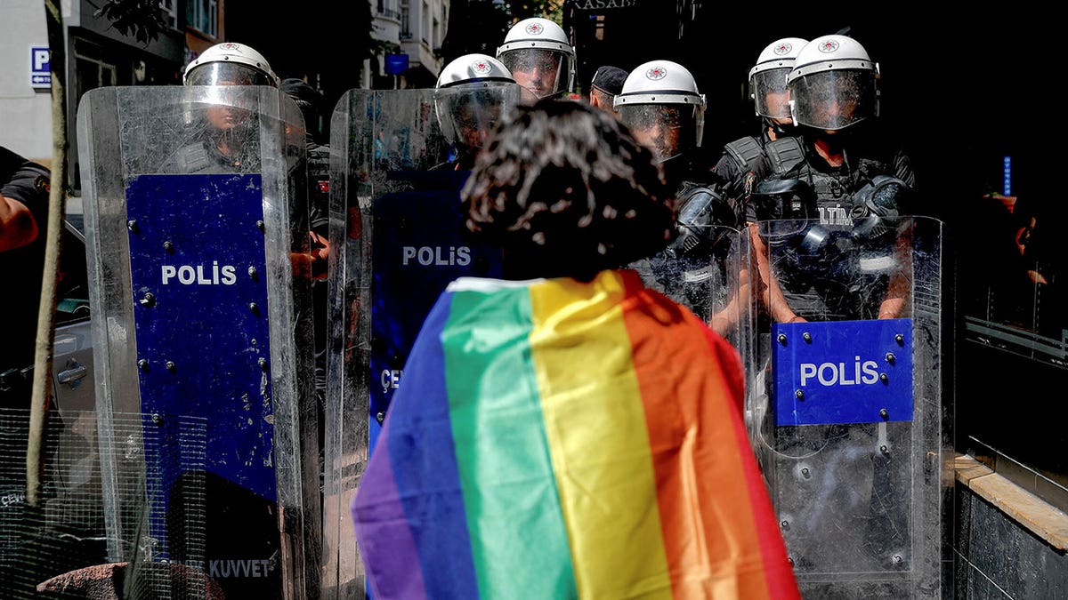 A Pride parade goer in front of the police