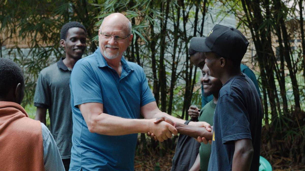 missionary shakes hands another man