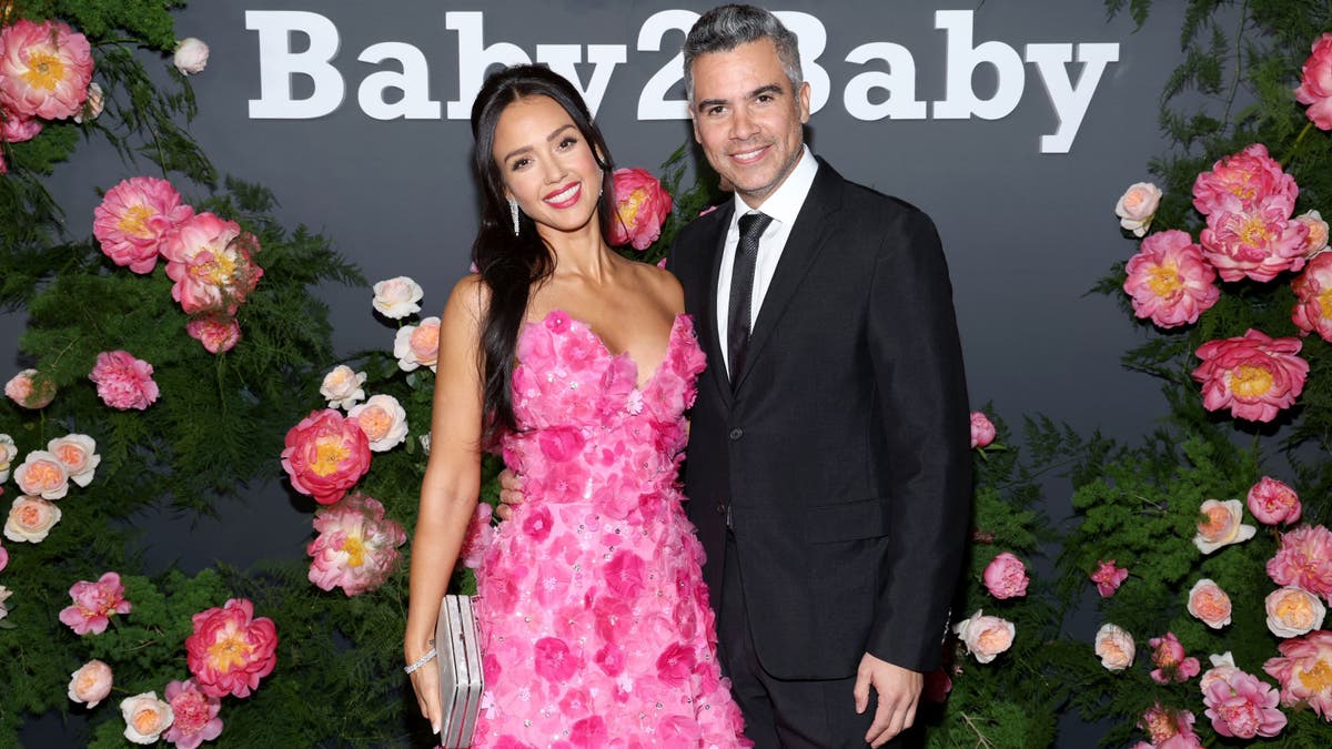 Jessica Alba in a pink dress posing with Cash Warren