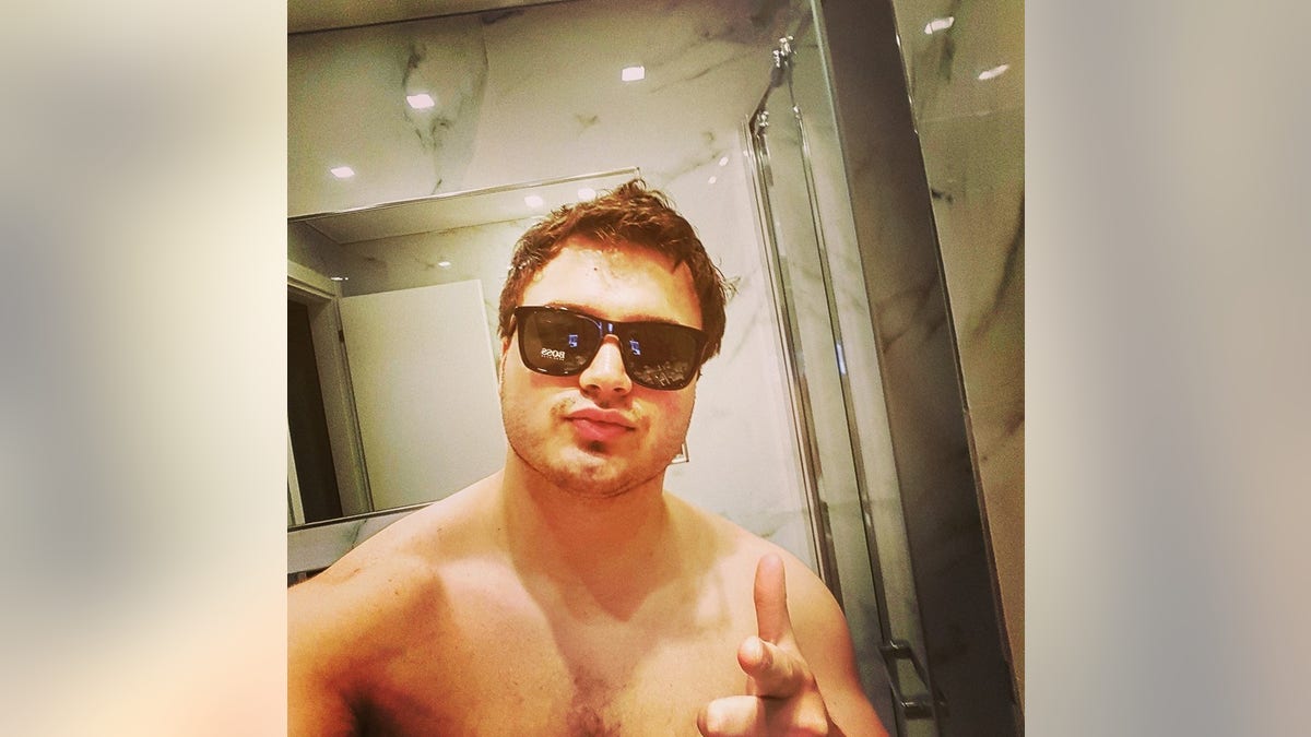 John Daniels in a Facebook selfie, shirtless wearing sunglasses