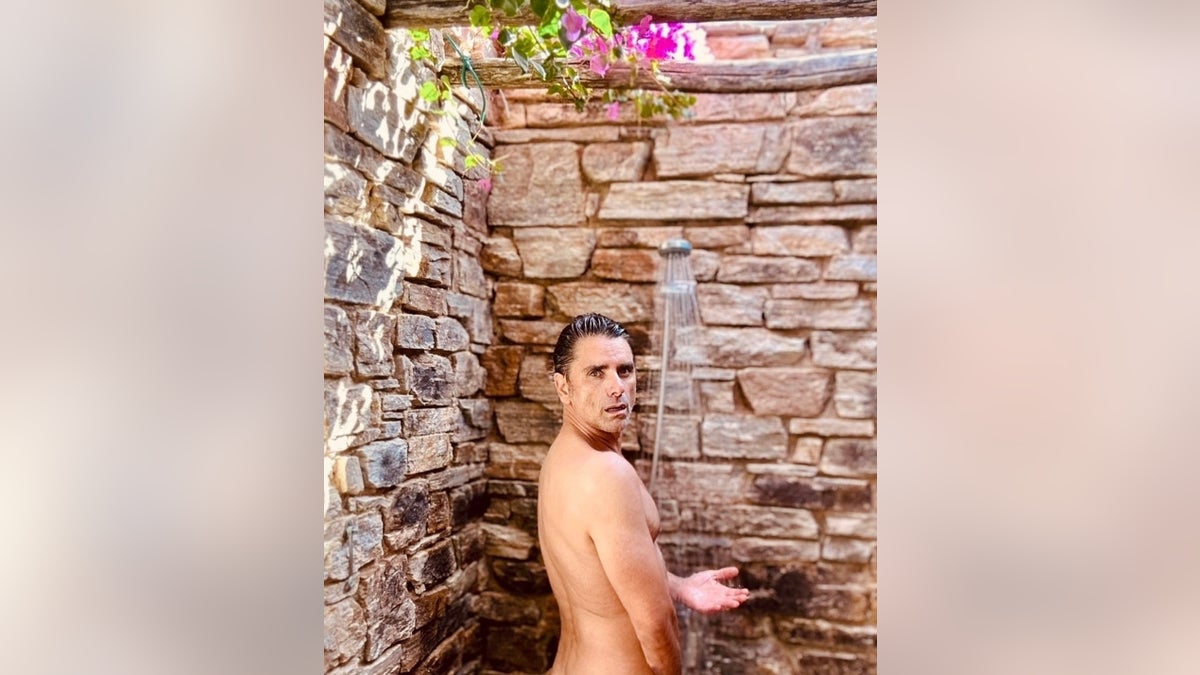 John Stamos posing nude in an outdoor shower