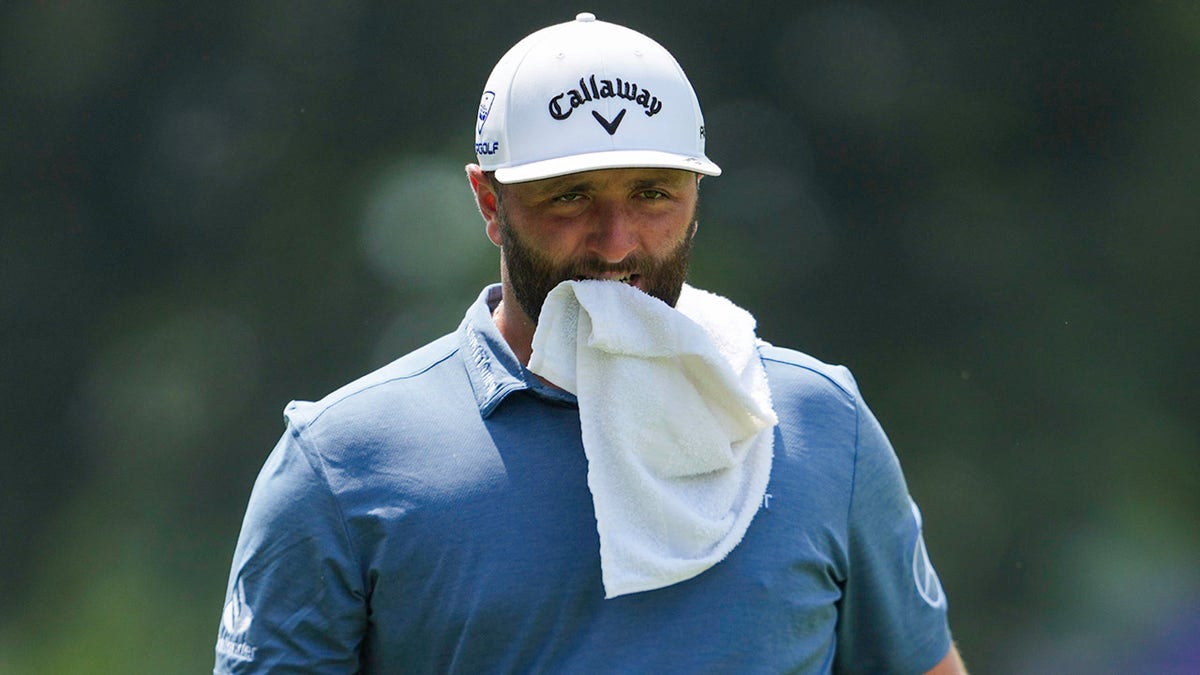 Jon Rahm walks down with towel