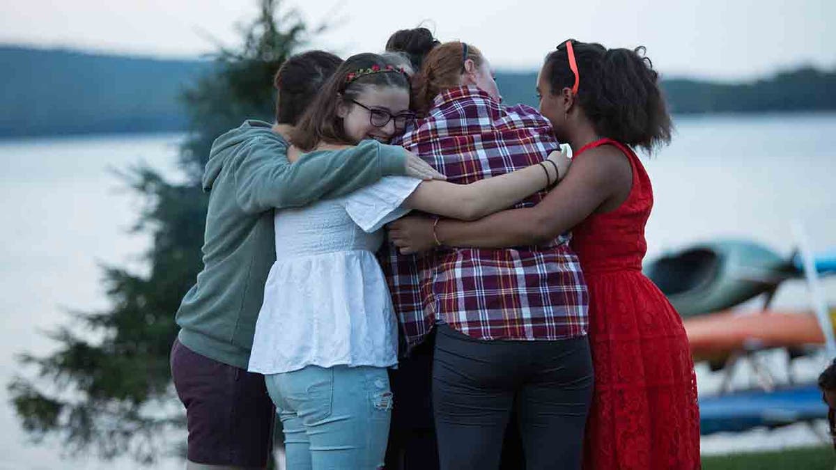 female Camp Kita campers in a group hug