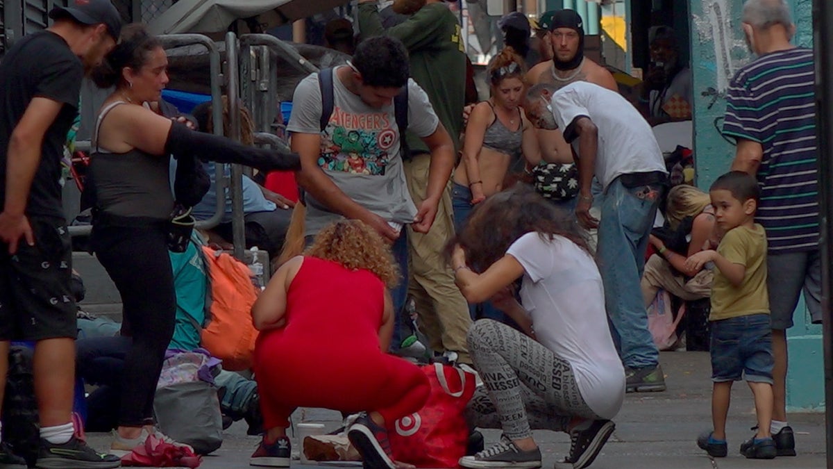 Drug addicts doing drugs on Kensington streets in Philadelphia in front of a young child