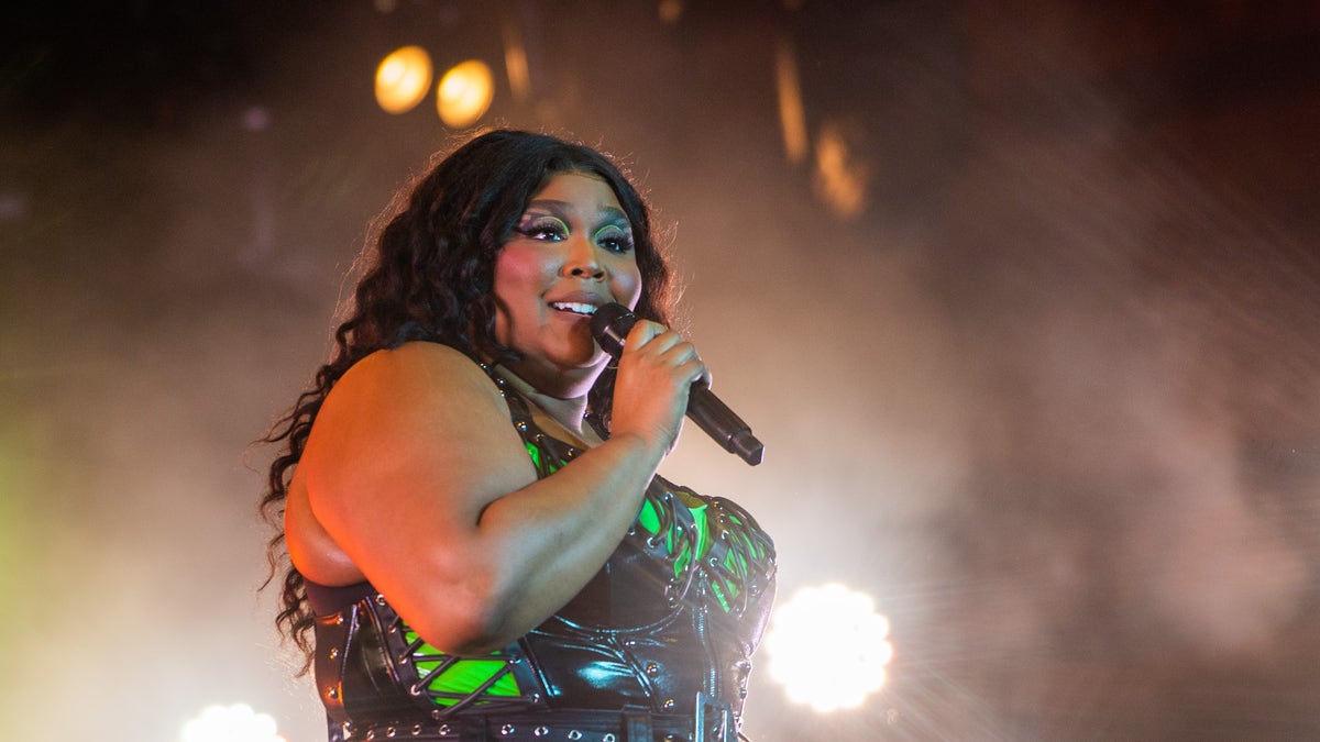 Lizzo performing on stage with a microphone