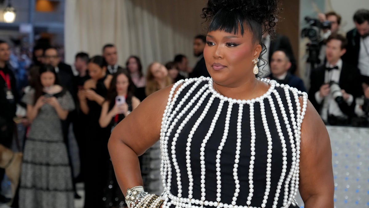 Lizzo in a black and white dress with her hair up at the Met Gala