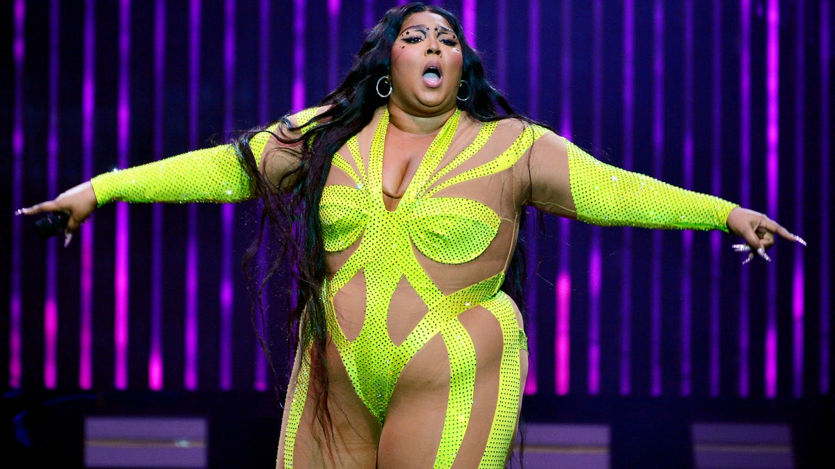 Lizzo in yellow spandex outfit performing on stage