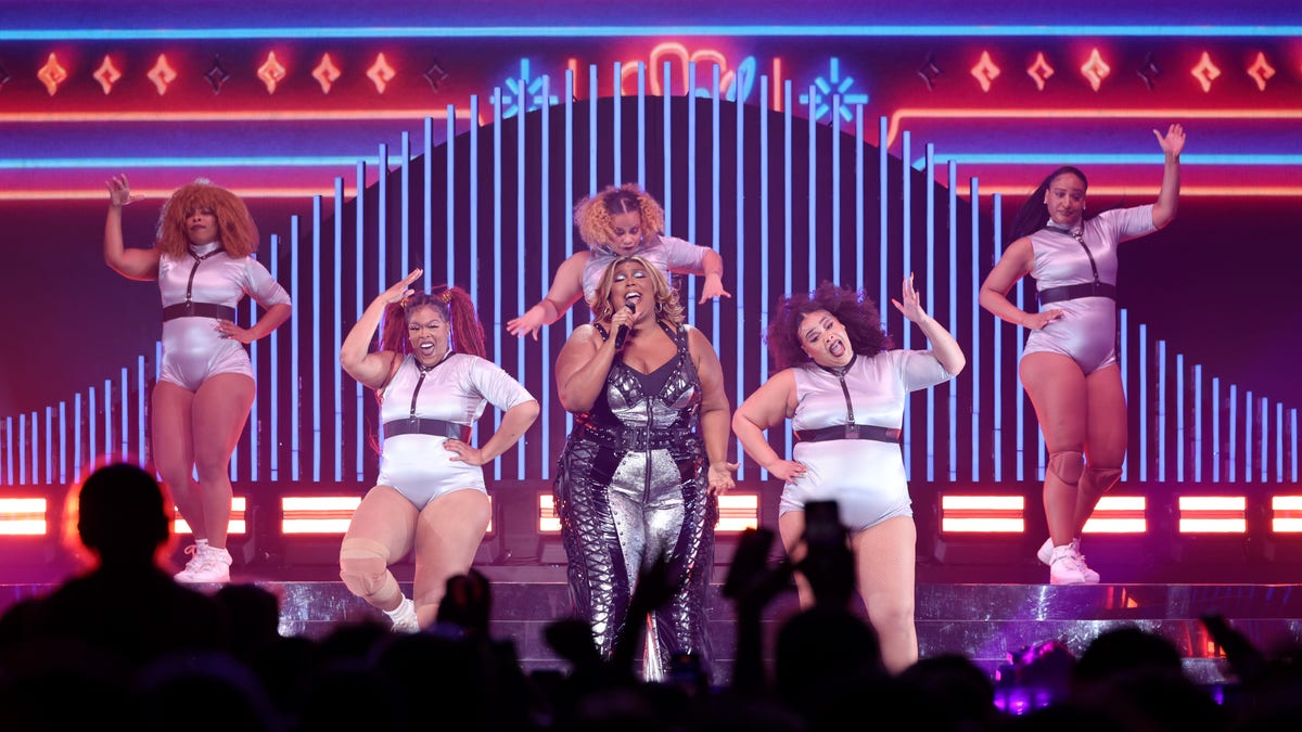 Lizzo on stage performing with her backup dancers during "The Special Tour"