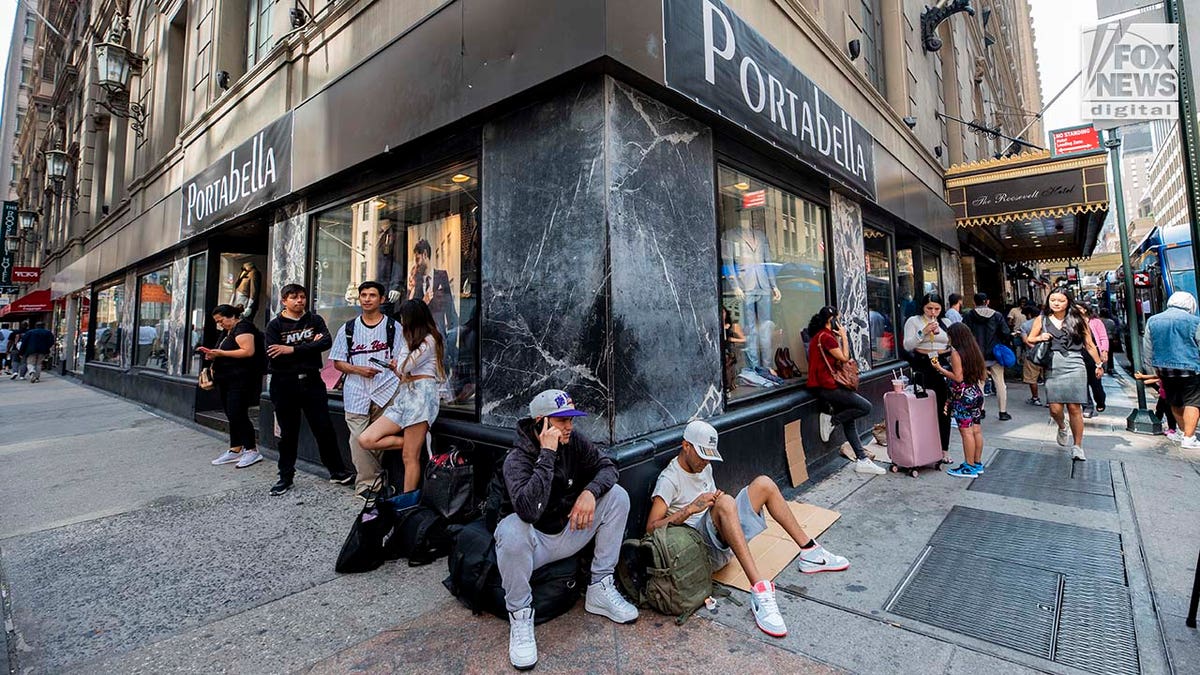 Migrants sitting on Manhattan street corner