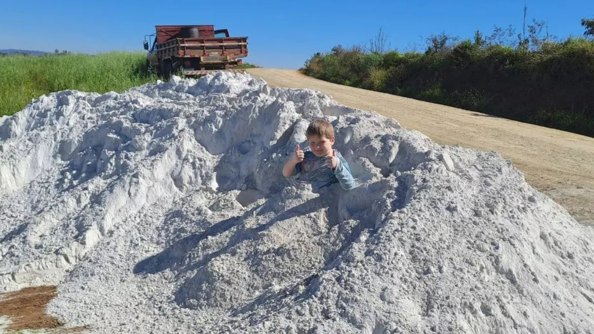 child playing in limestone dust pile