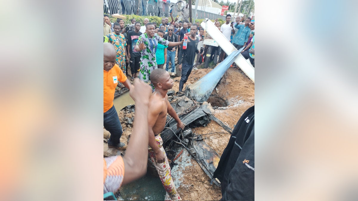 Lagos plane crash wreckage surrounded by onlookers