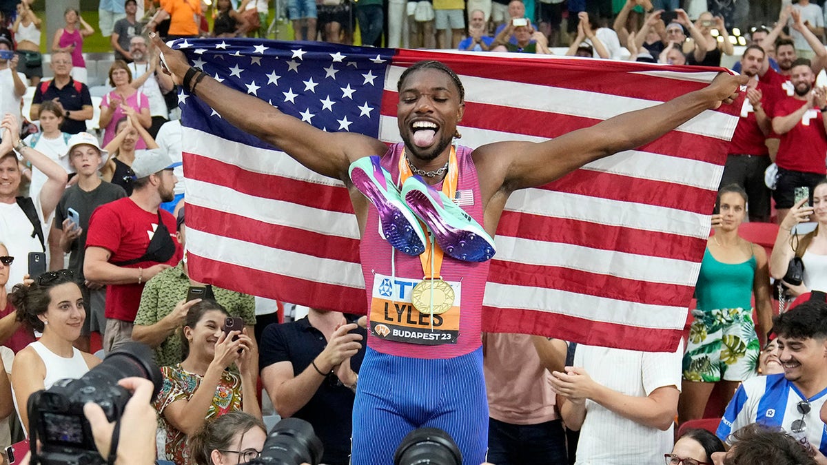 Noah Lyles holds the American flag