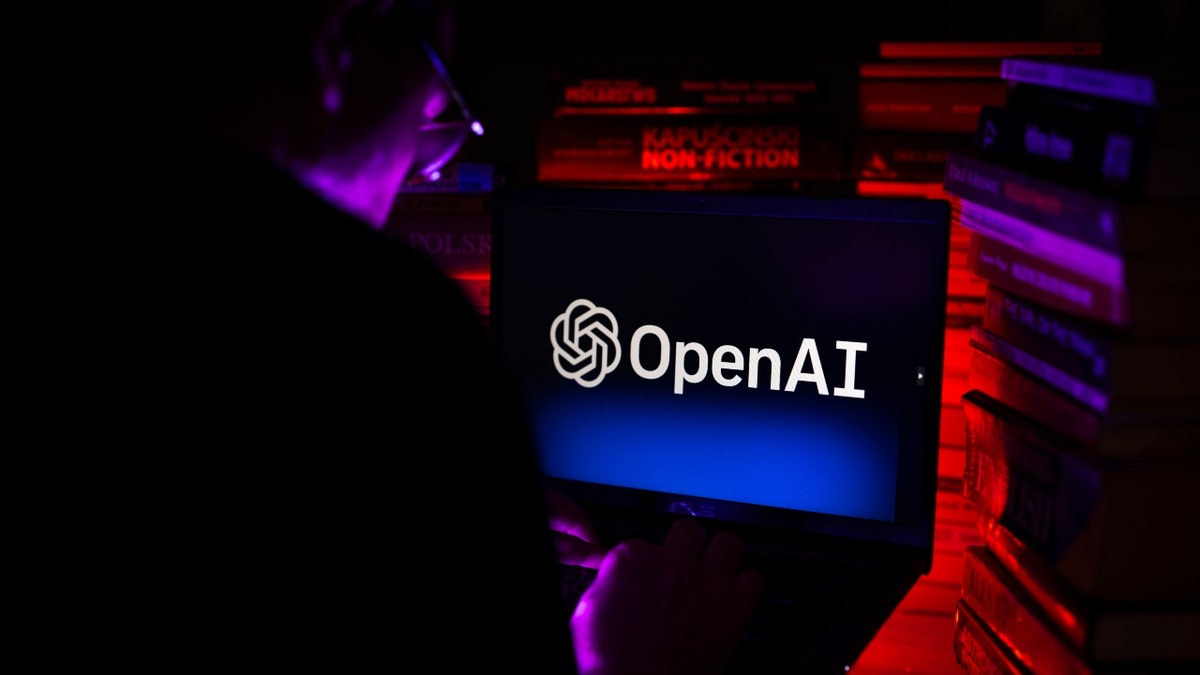 The man looks at the OpenAI logo on the screen.