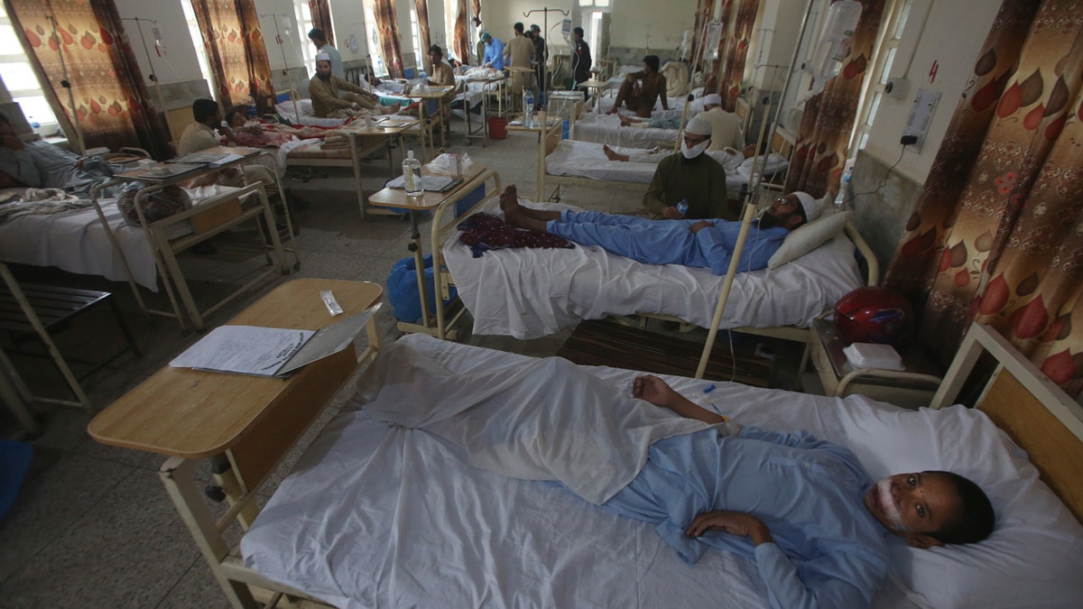 Injured people lie on hospital beds