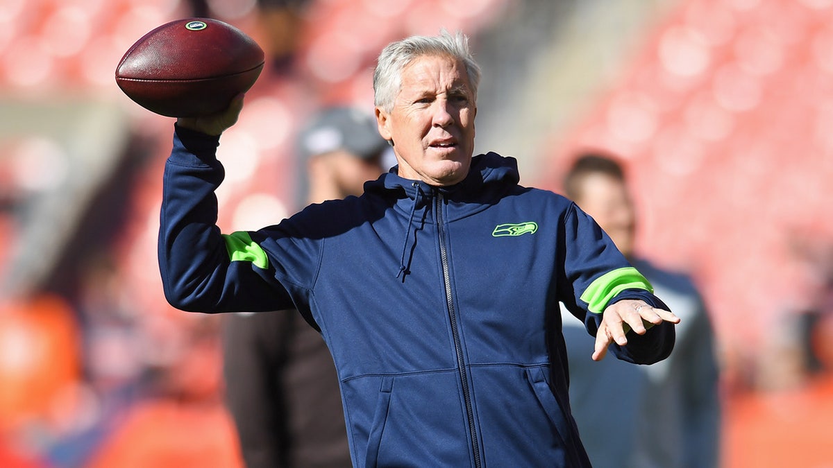 Pete Carroll throws passes before a game