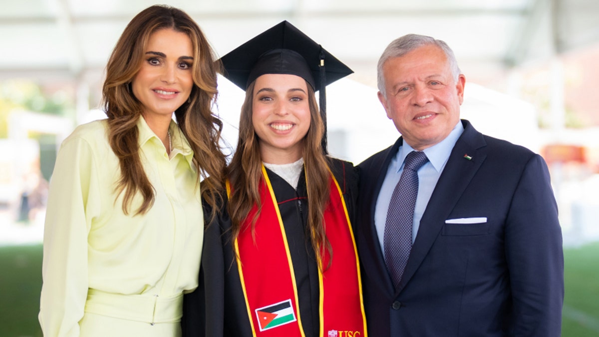 Princess Salma in her graduation cap and gown with her mother in a yellow dress and her father in a navy suit