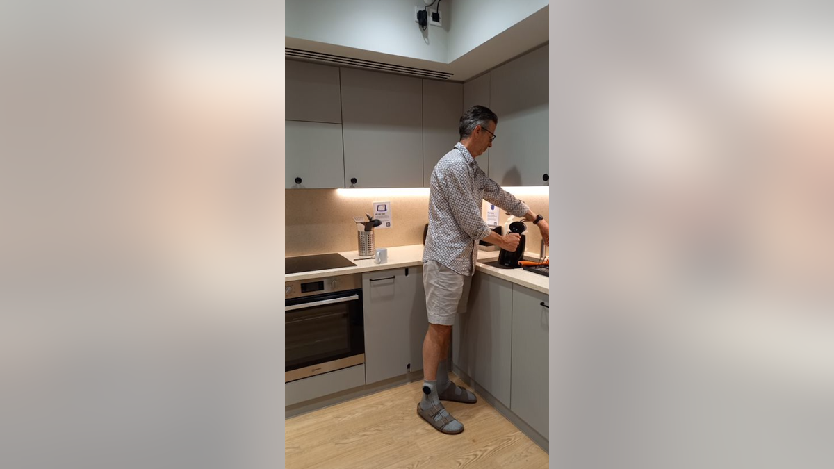 man models SmartSocks while standing in kitchen