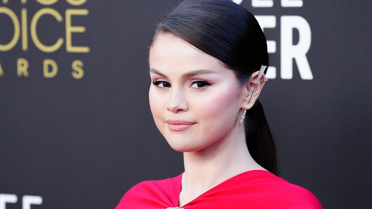 Selena Gomez in a red dress with her hair slicked back