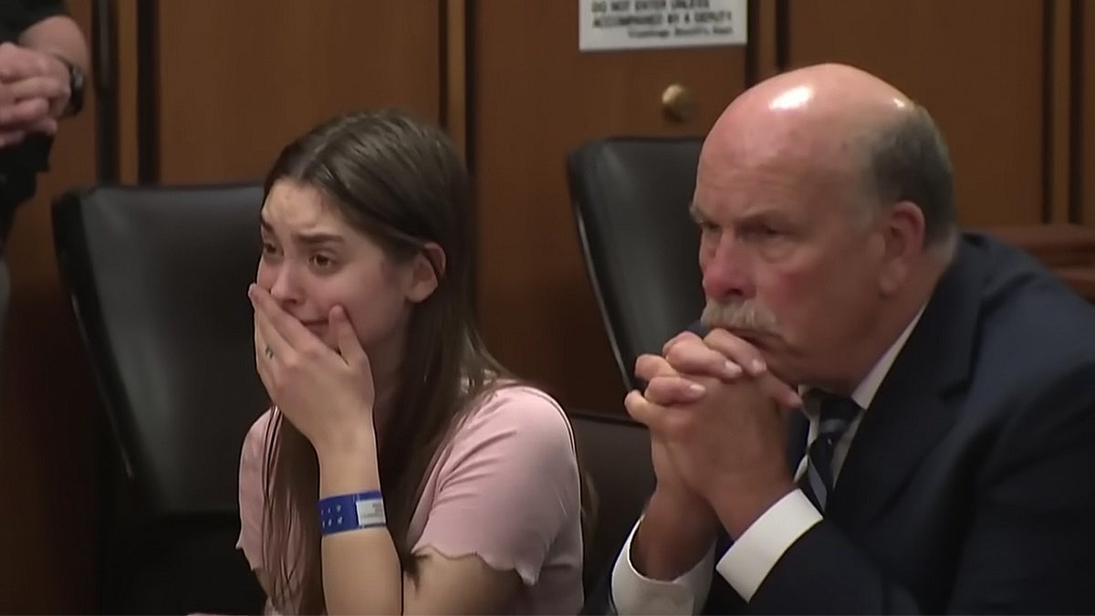 Ohio woman weeps and covers mouth in courtroom.
