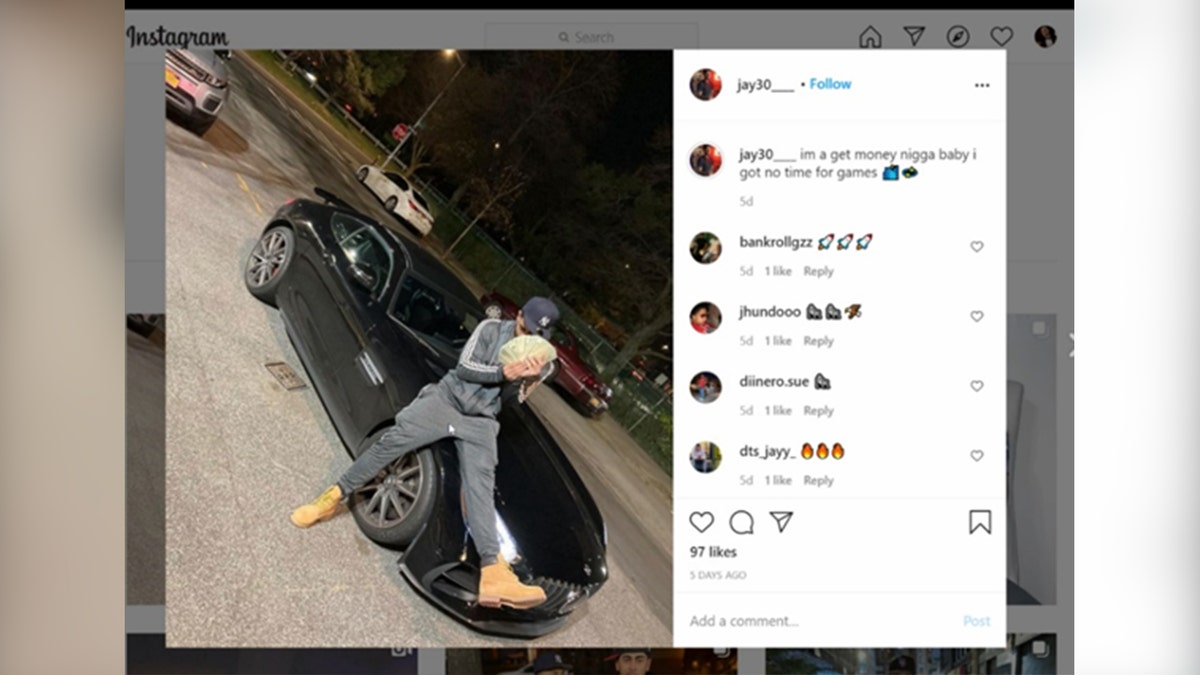 Screenshot of a social media post showing a man holding a large quantity of cash while sitting on the hood of his car.