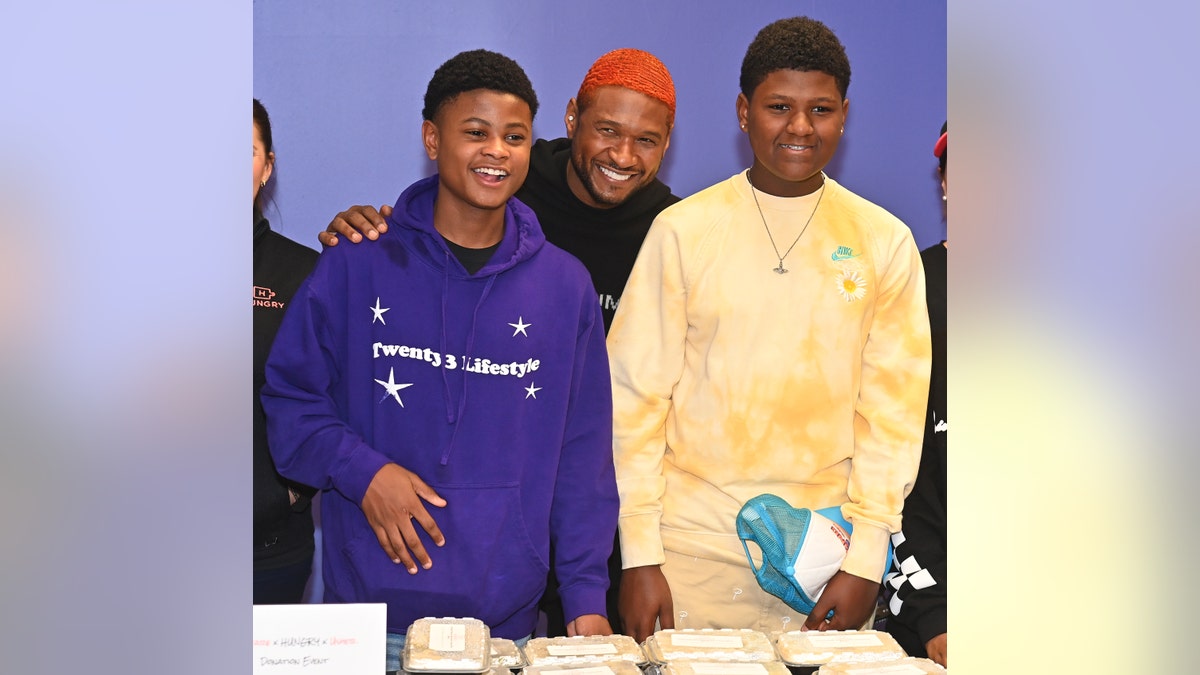 Usher posing with two of his sons