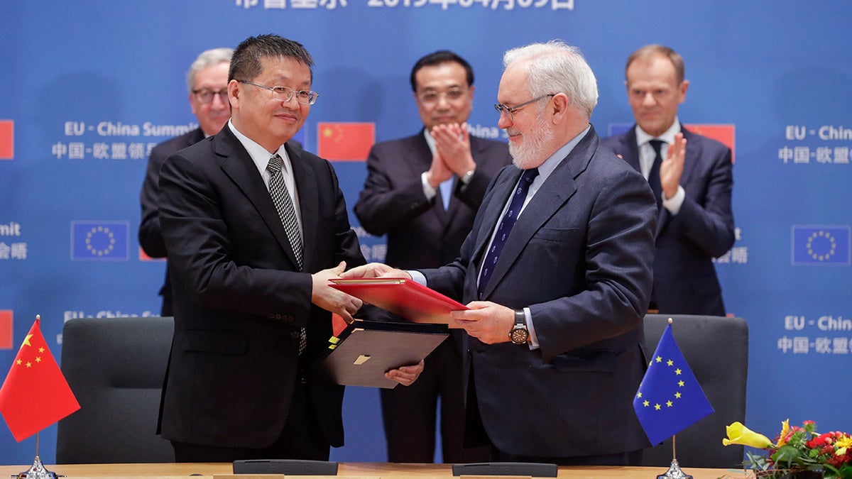 Chinese Minister of Energy Zhang Jianhua and European Climate Commissioner Miguel Arias Canete shake hands at a EU-China summit in Brussels on April 9, 2019.