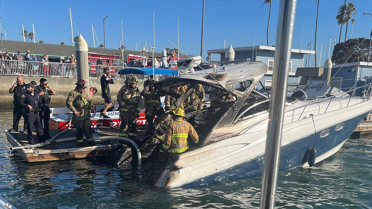 firefighters investigate charred boat 
