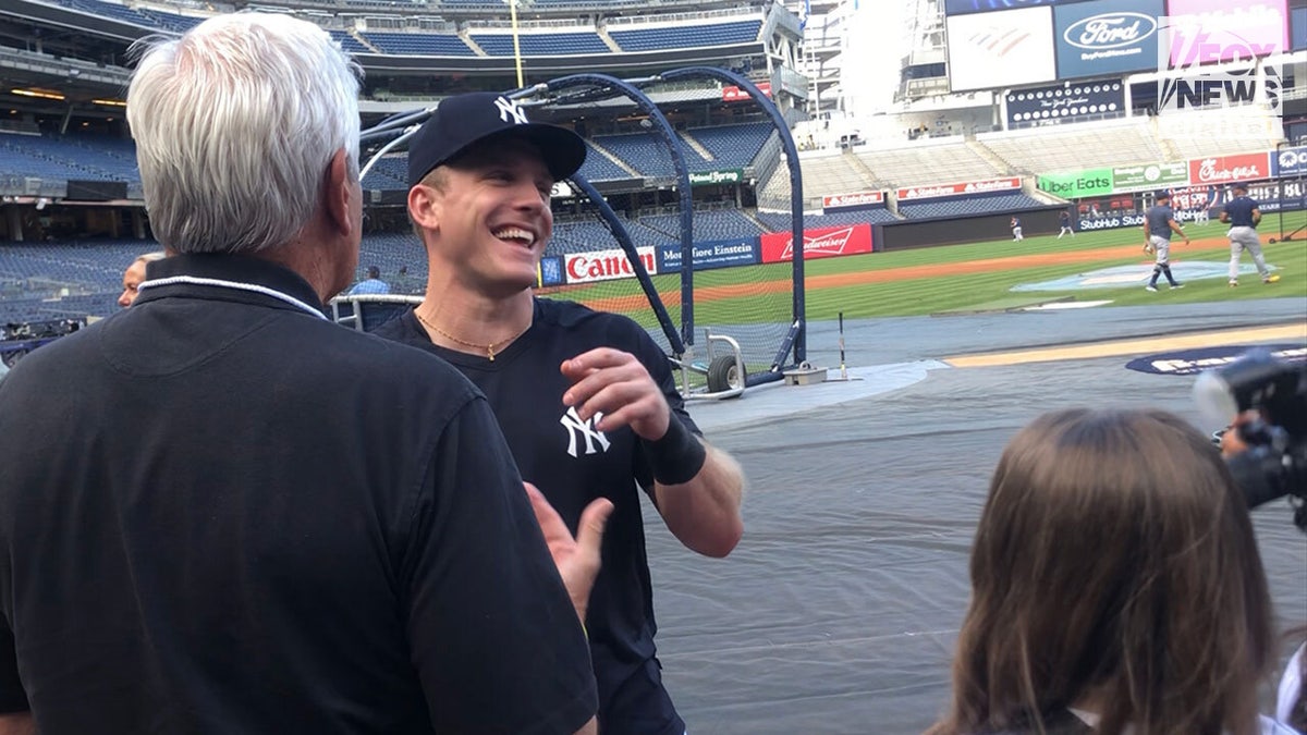 Blakeman and Cardona laugh on the field with Yankees player Harrison Bader