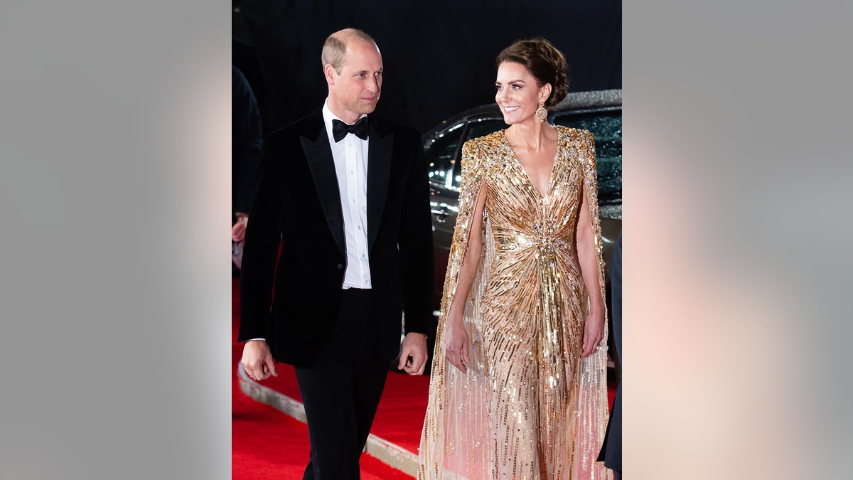 Kate Middleton wearing a golden sparkling gown next to Prince William in a suit
