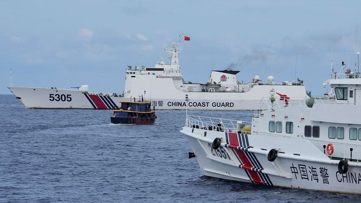 Filipino supply boat maneuvers around Chinese coast guard ships 