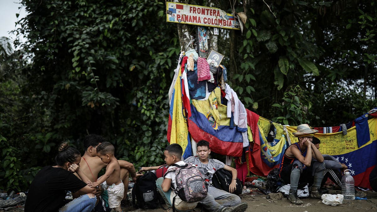 migrants sitting at panama, colombia border