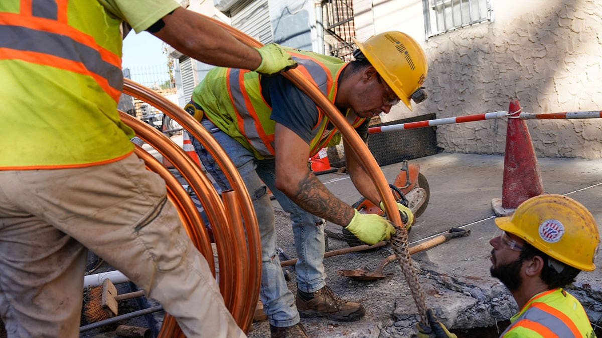 Workers replace pipes