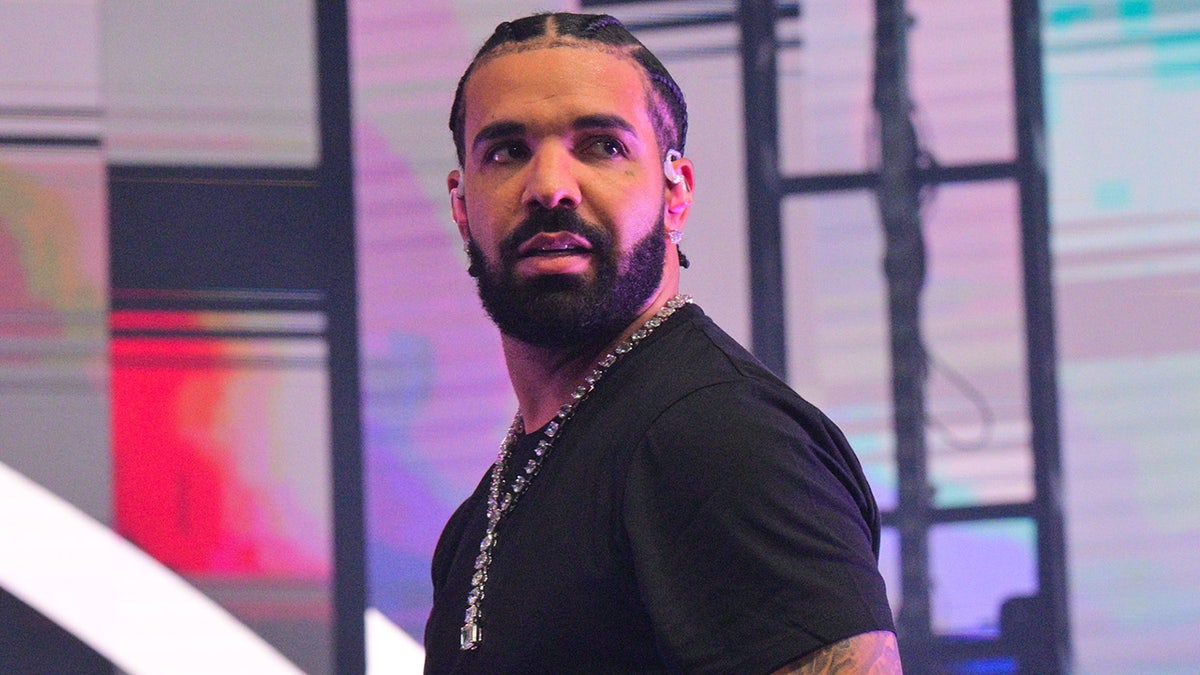 Drake mira hacia la multitud mientras actúa en Atlanta con una camisa negra.
