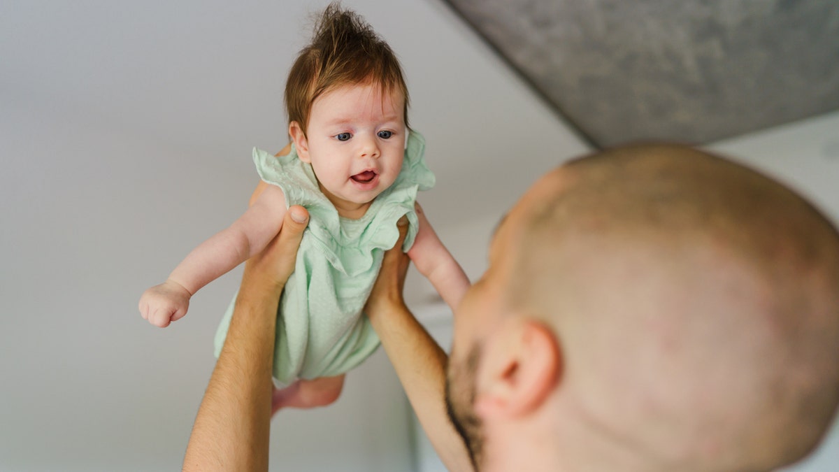 Father throwing baby
