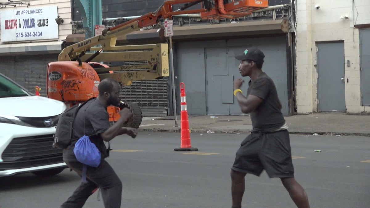 Two people hold their fists up to fight