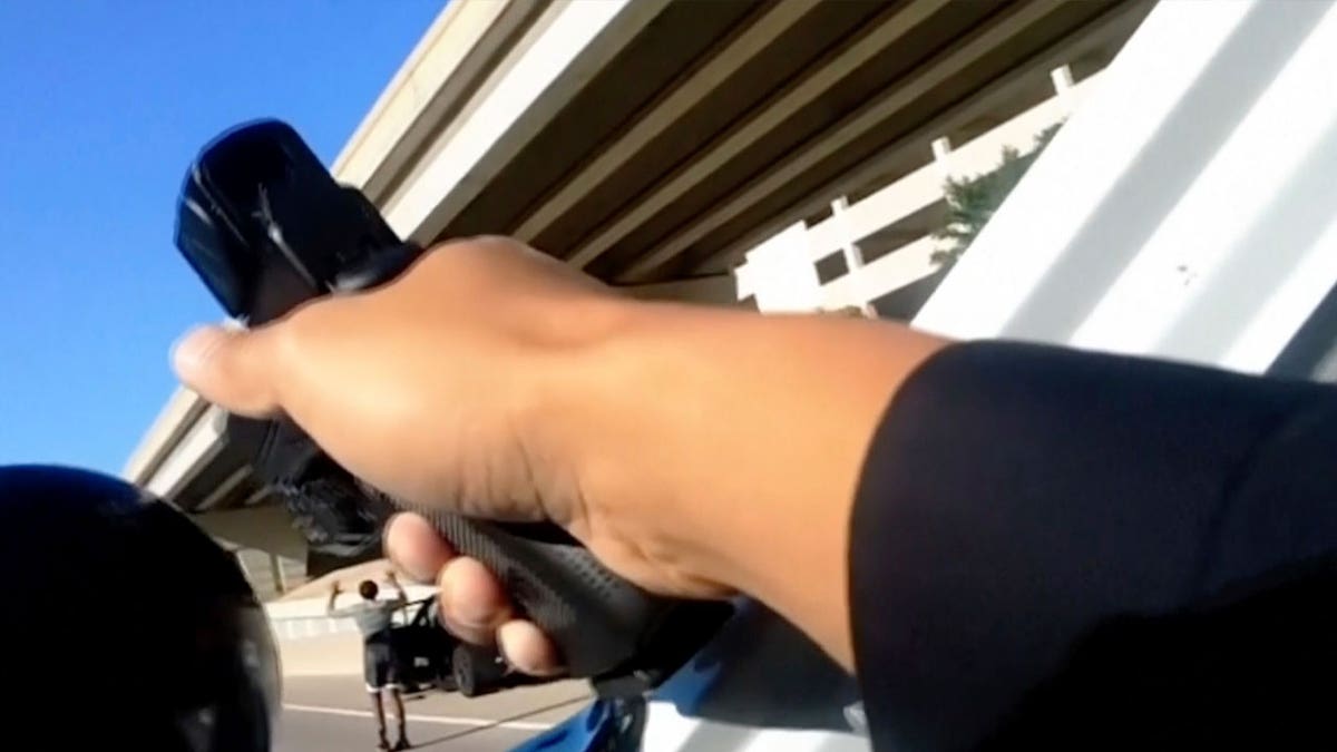 body camera image of police pointing a gun at a woman