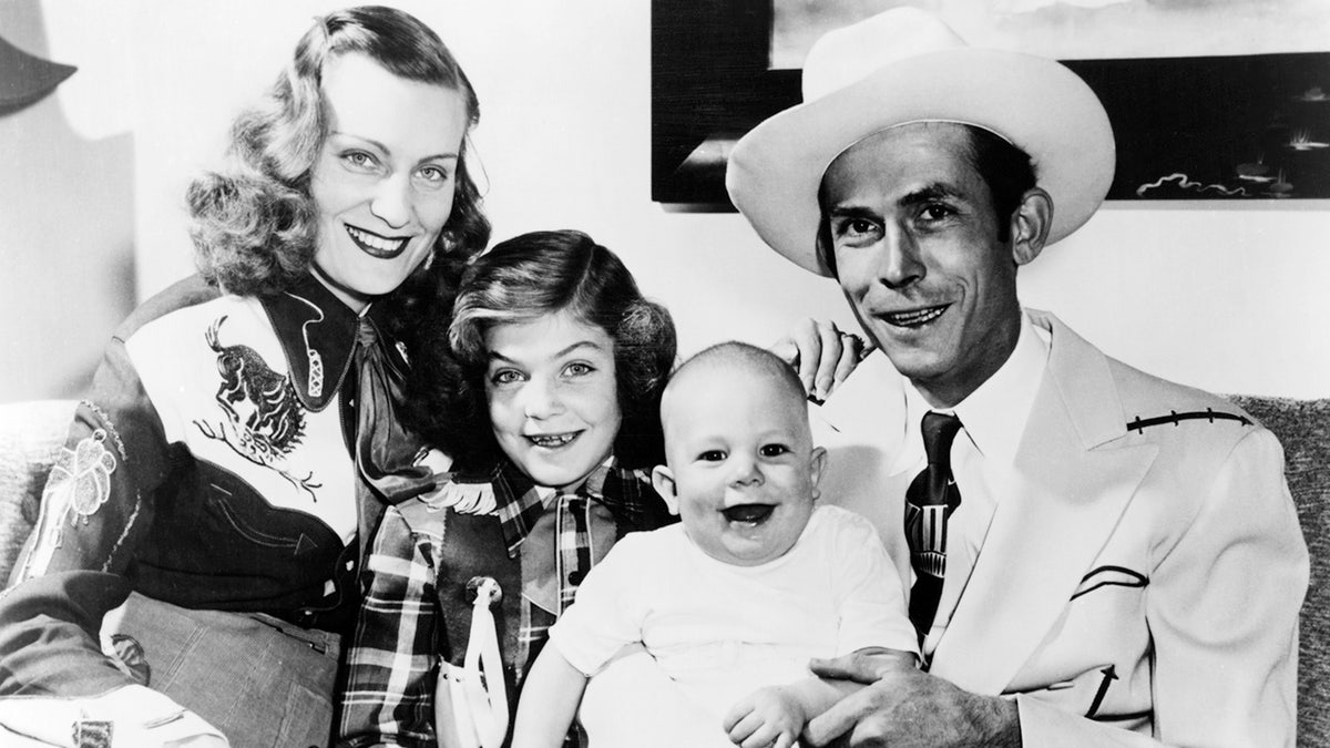 Hank Williams in a light colored hat with his wife, Audrey Williams, her daughter Lycretia from a separate relationship, and Hank Williams Jr. being held by his father