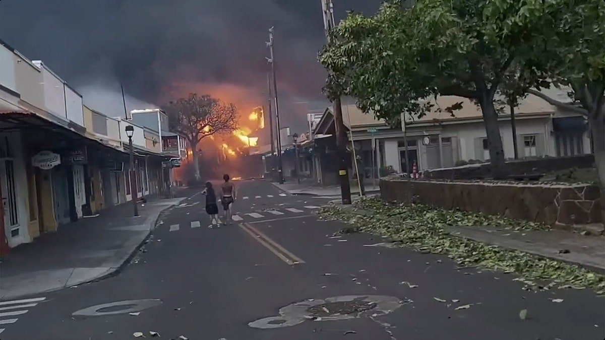 people in street as fire rages