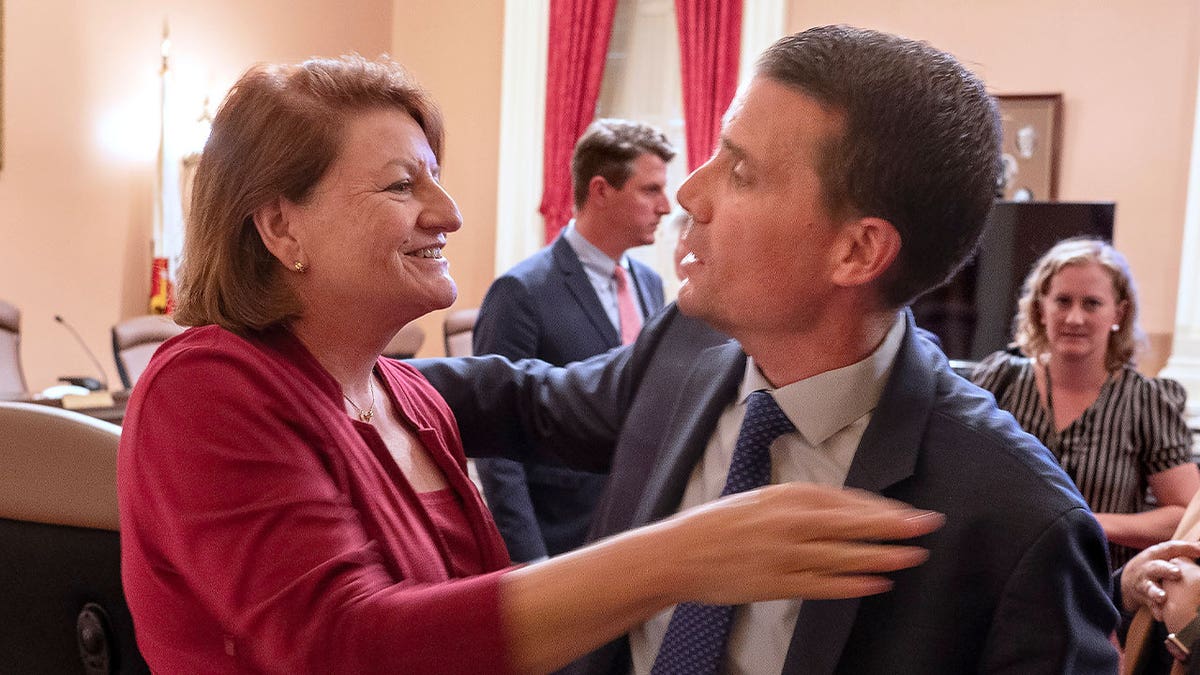 Senate President Toni Atkins, left, hugs Sen. Mike McGuire 