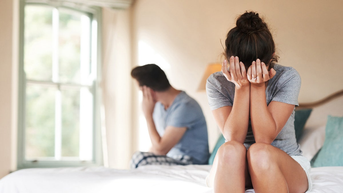 Couple disagreeing on dog in the bed