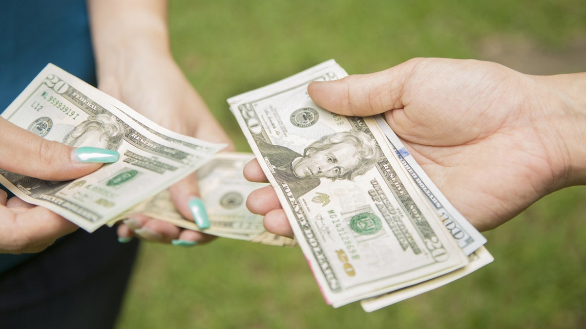 Two women exchange money.