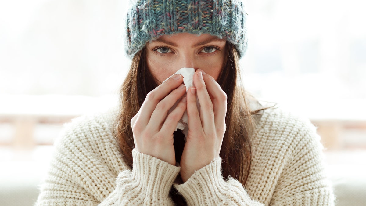 Woman blowing nose