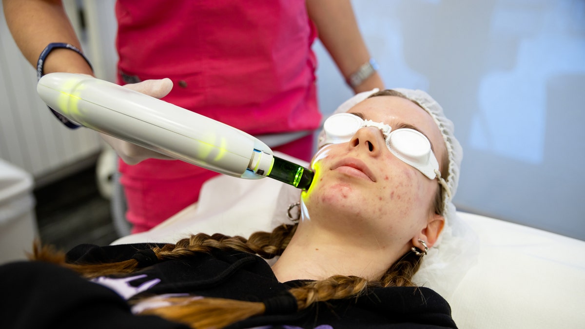 Woman gets laser treatment for acne.